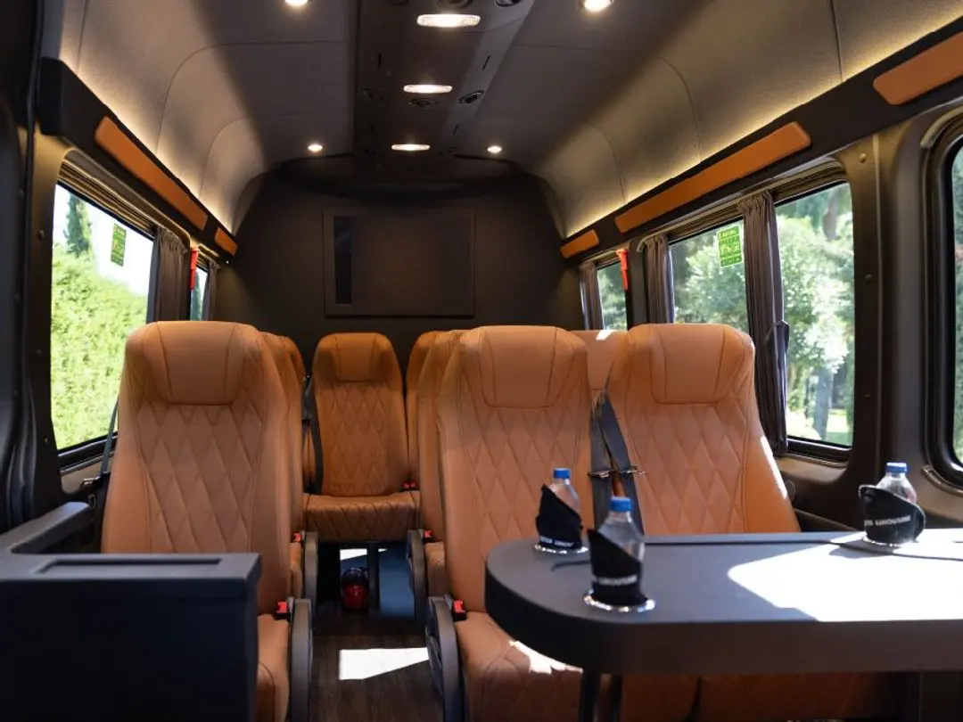 Mercedes Sprinter VIP cabin aisle with tan leather seats and rear screen