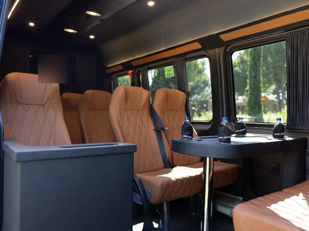 Mercedes Sprinter VIP cabin with tan leather club seats and tables