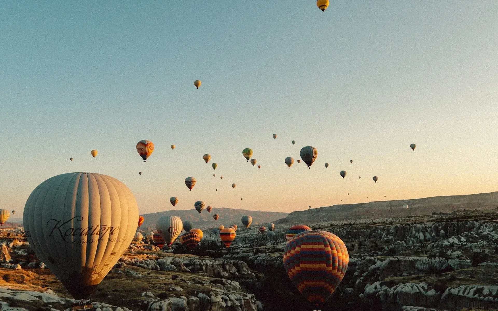 Dozens of balloons over the valleys at sunrise