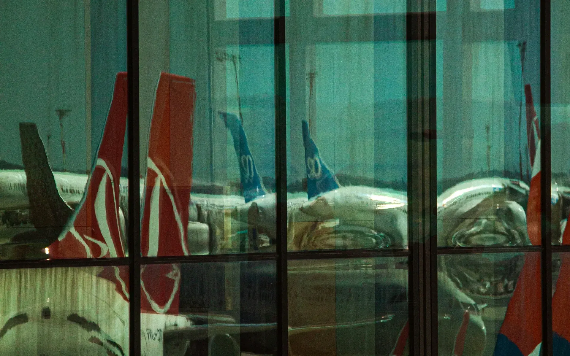 Turkish Airlines tails reflected in the terminal glass at Istanbul Airport