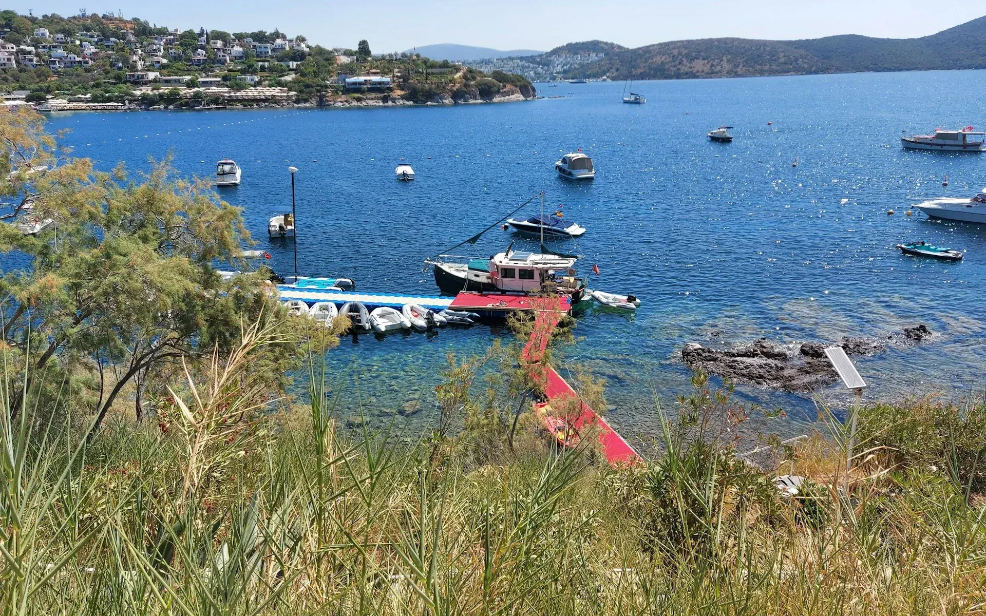 Small boats and a red pier in a calm bay near Bodrum