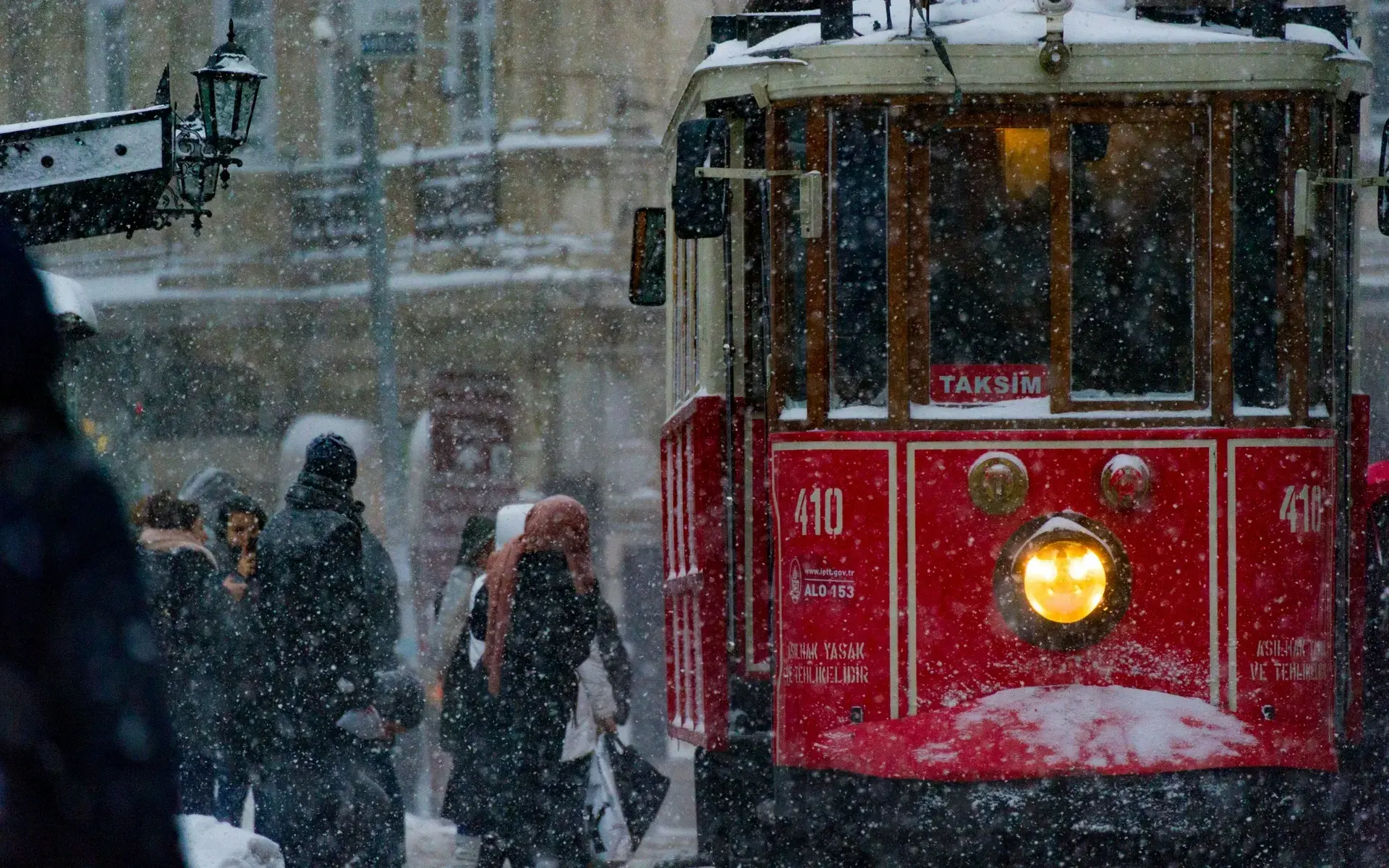 Istanbul's red nostalgic tram on İstiklal Avenue in falling snow