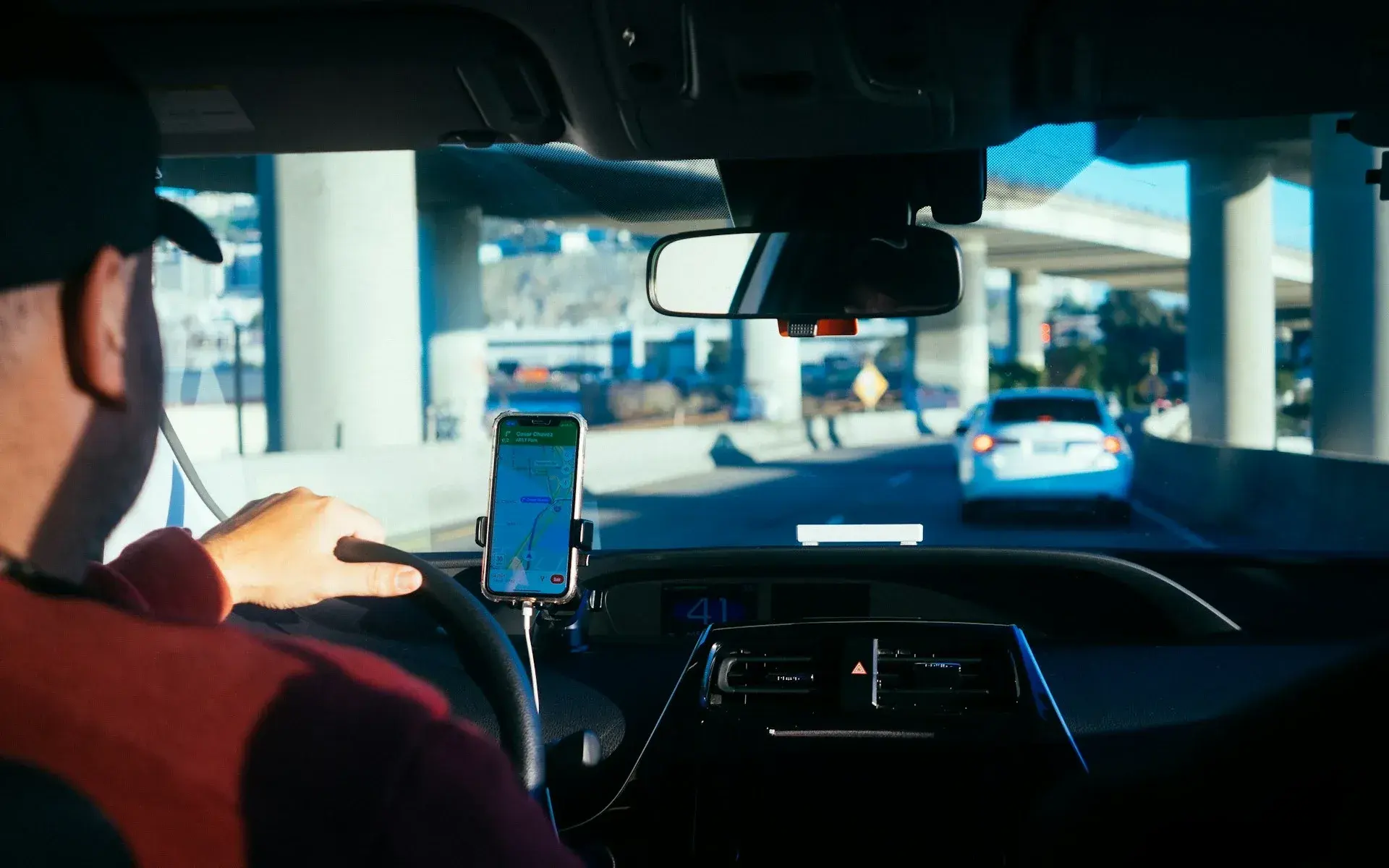 Driver following a navigation app mounted on the dashboard