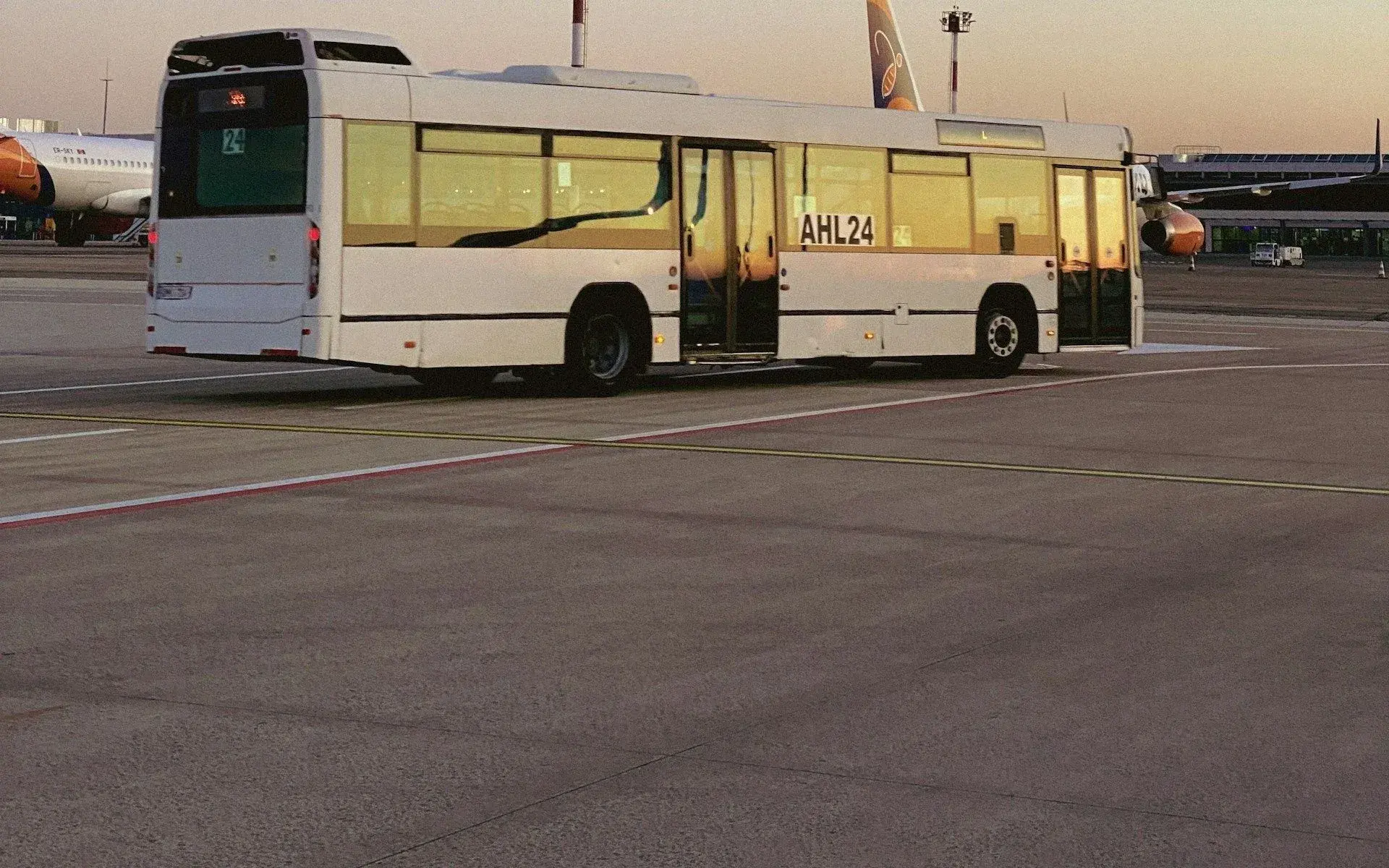 Airport shuttle bus waiting on the apron at dusk