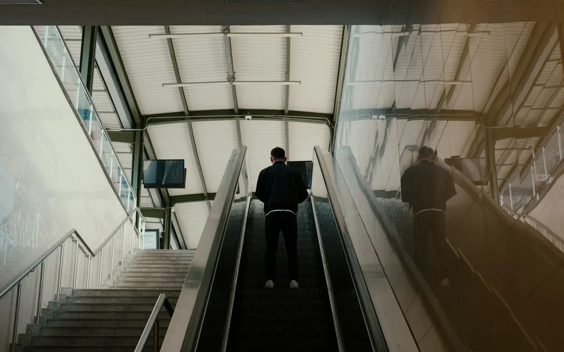 A traveller riding an escalator up from a metro platform