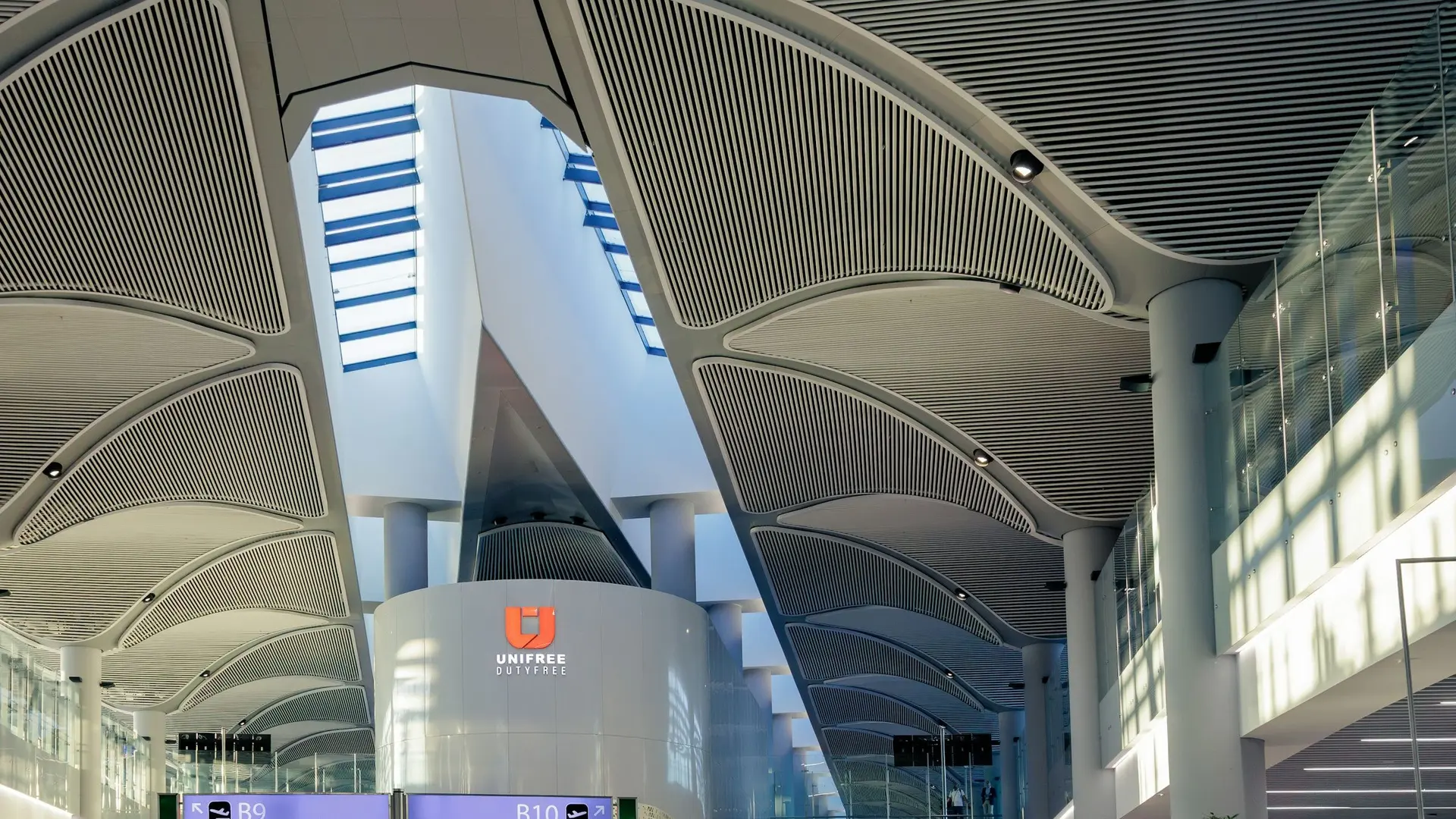 Istanbul Airport terminal hall with its vaulted ceiling and passengers walking to the gates